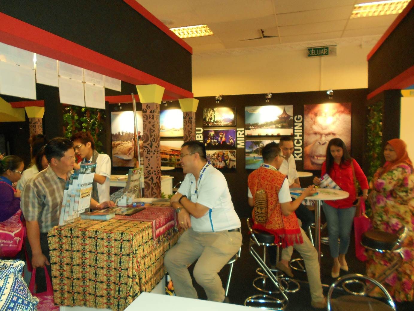 An exhibitor at the Sarawak booth taking time to explain the packages on offer to interested visitors.